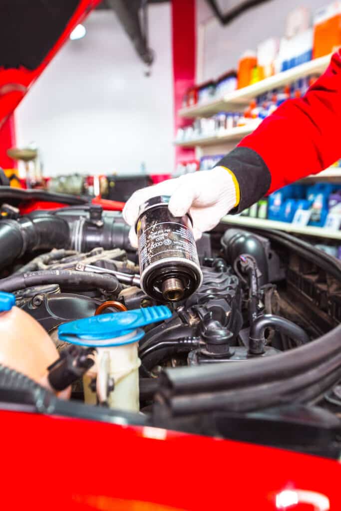 An old Mahle OX 388D oil filter being removed from an Audi A3
