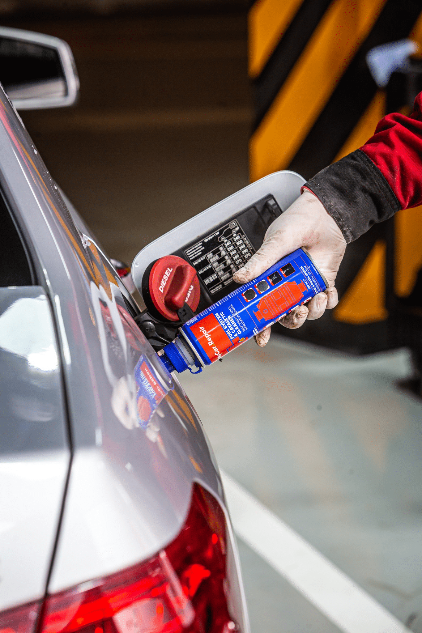 A picture of a person adding a diesel injector cleaner to a fuel tank