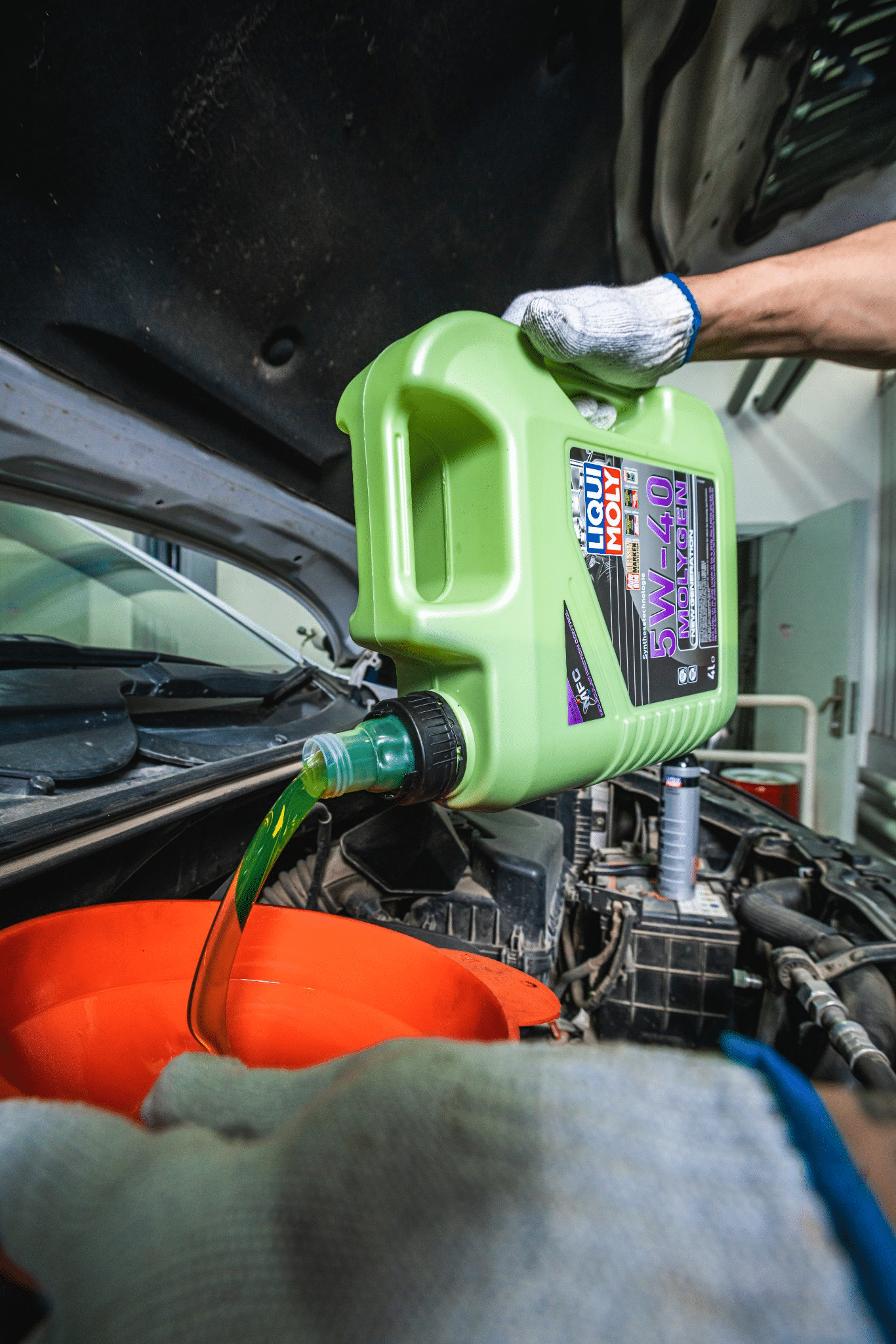 A car with the engine oil being topped up