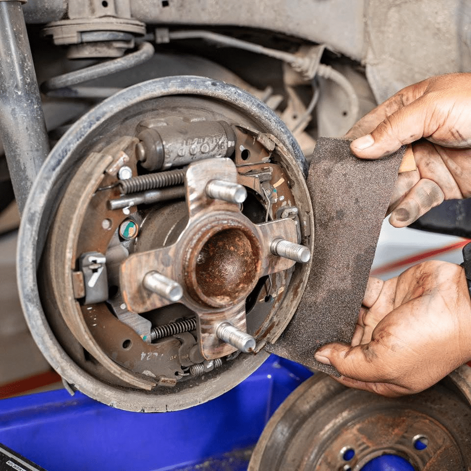 A person inspecting brake components for wear
