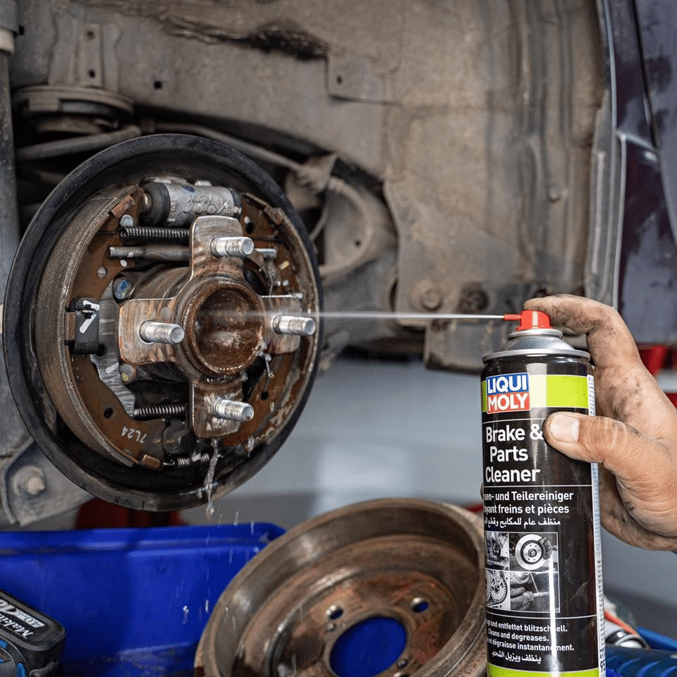 A mechanic lubricating a car brake system